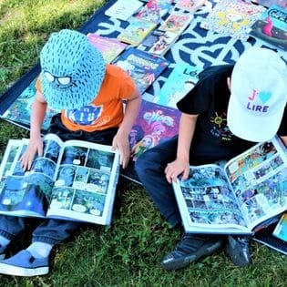 Enfants en train de lire à l'extérieur