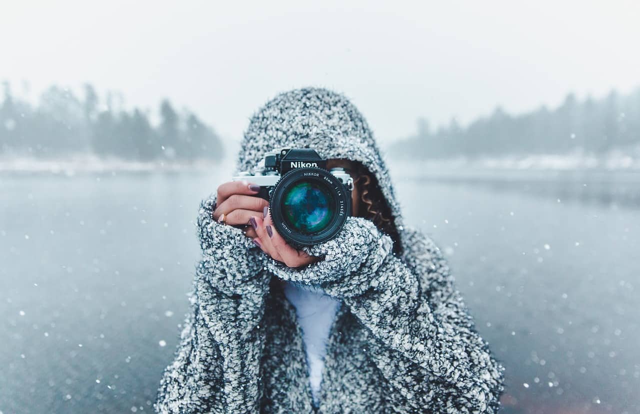 une femme prenant une photo en plein hiver